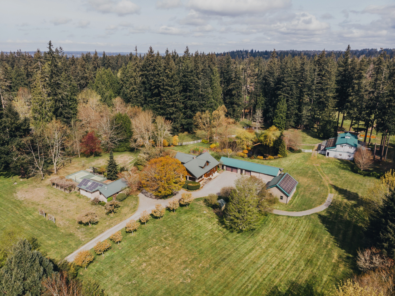 oblique image of Big Rock Park South showing buildings with solar panels in the middle of large grassy fields surrounded by conifers